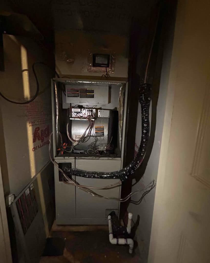 Aging furnace closet with exposed wiring before replacement