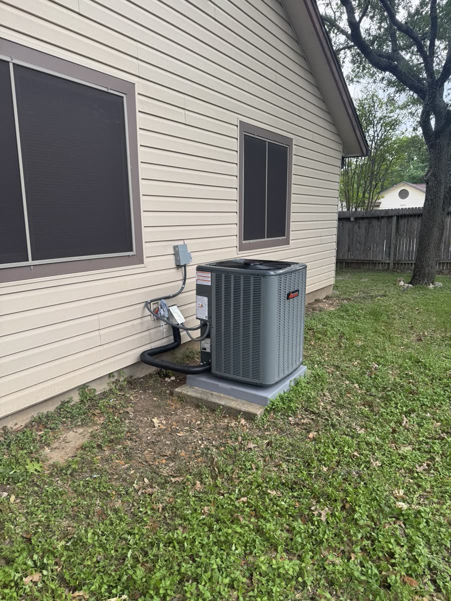 New Amana condenser on a raised pad behind a home